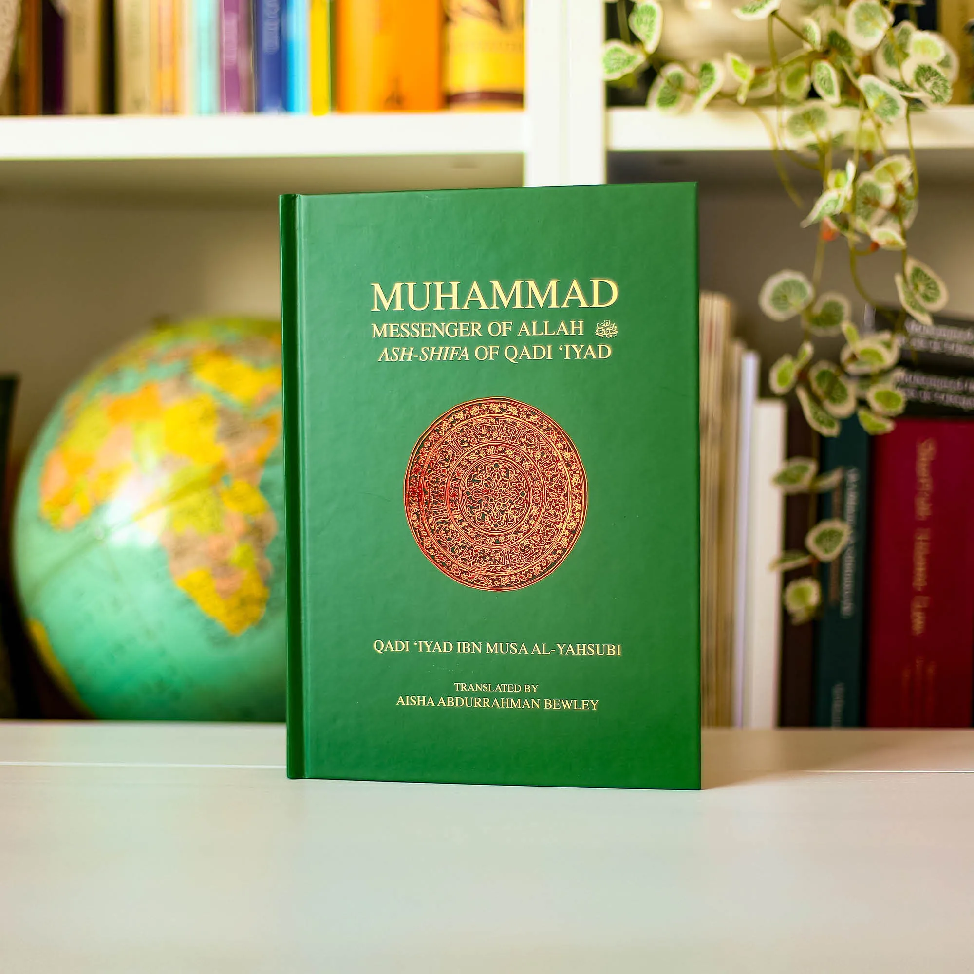 Upright book in library of Muhammad, the Messenger of Allah, Ash-Shifa of Qadi ‘Iyad, Aisha Bewley. Healing Seerah by Ta-Ha Publishers.