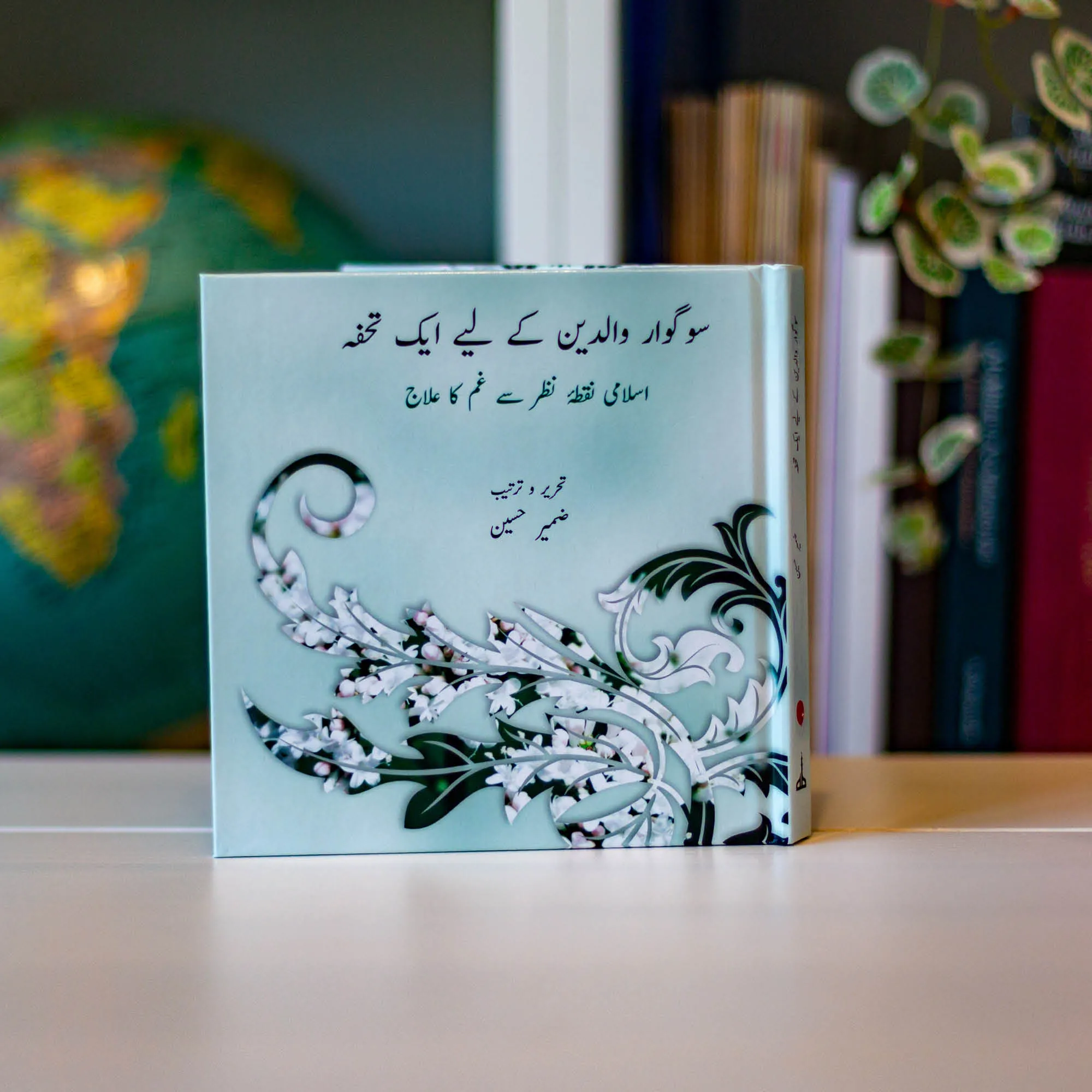 Upright book in library of A Gift for the Bereaved Parent by Zamir Hussain, Shabana Maqsood. Urdu child loss guide by Ta-Ha Publishers