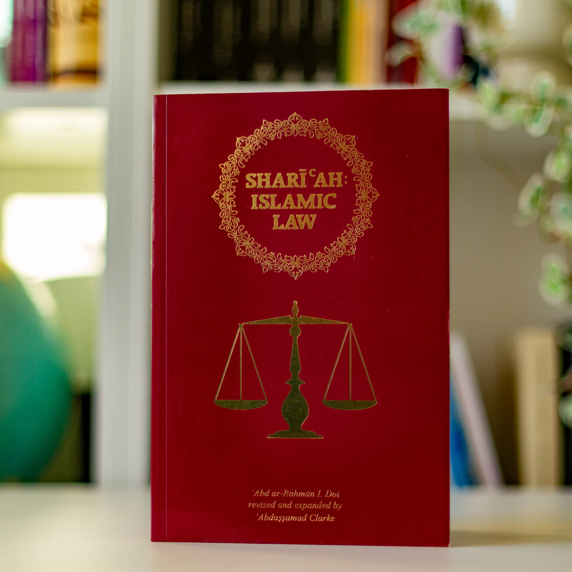 Upright book in library of Shari‘ah: Islamic Law by Abd ar-Rahman I. Doi, Abdassamad Clarke. Islamic Law textbook by Ta-Ha Publishers